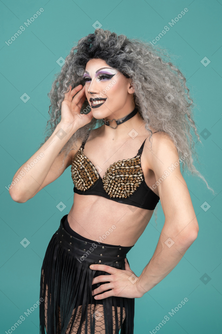 Drag queen smiling and touching their cheek
