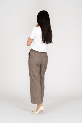 Vista posteriore di tre quarti di una giovane donna in calzoni