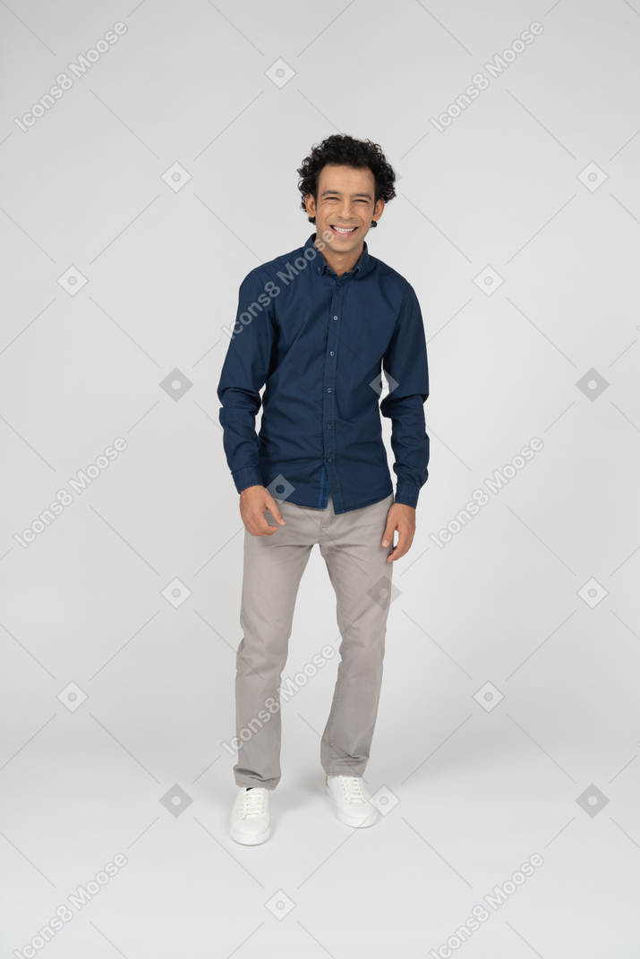 Vista frontal de um homem feliz em roupas casuais, olhando para a câmera