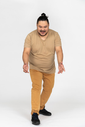 Cheerful asian man is about to lift something from the floor