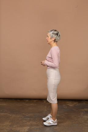 Donna sconvolta in abiti casual in piedi di profilo