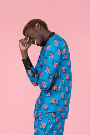 Black man in blue pajamas laughing