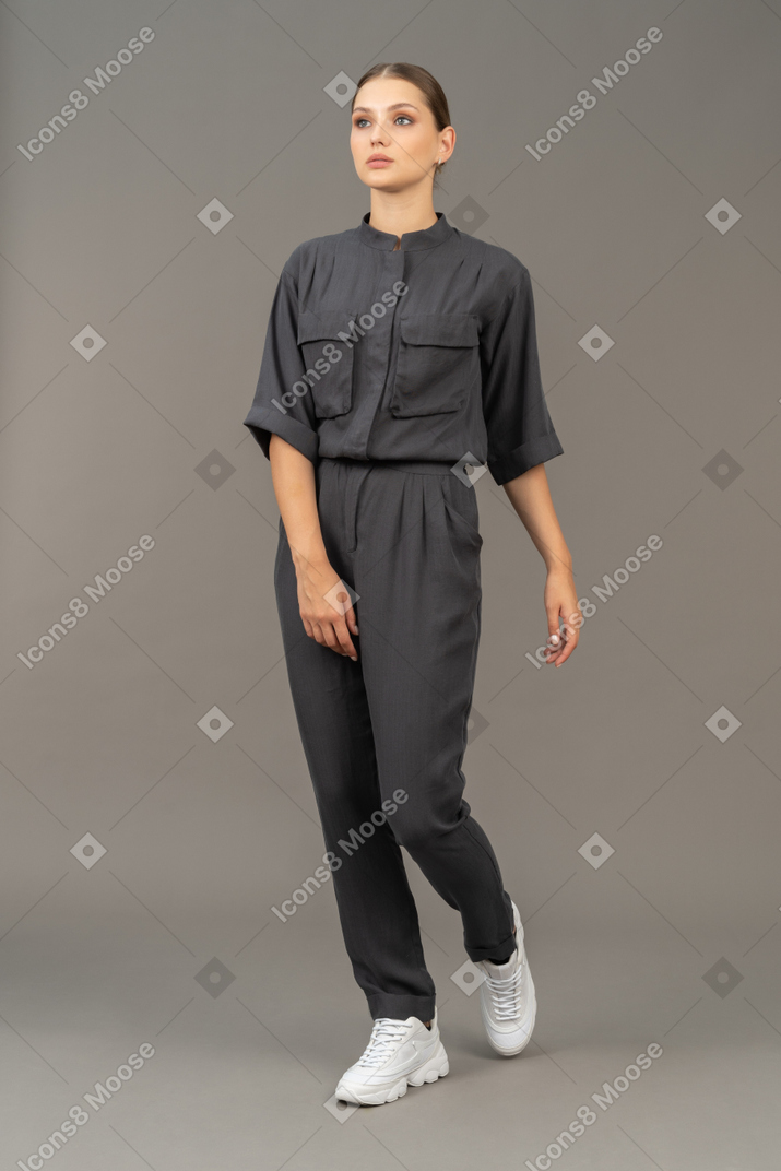 Three-quarter view of a walking young woman in a jumpsuit