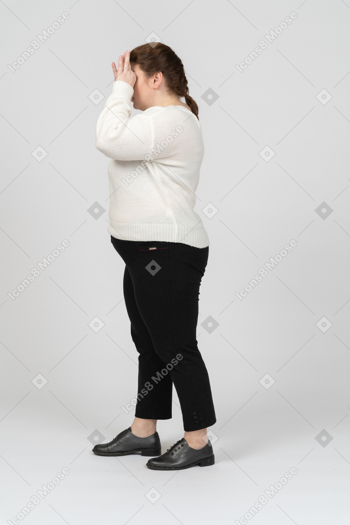 Donna grassoccia in abiti casual che guarda attraverso un binocolo immaginario