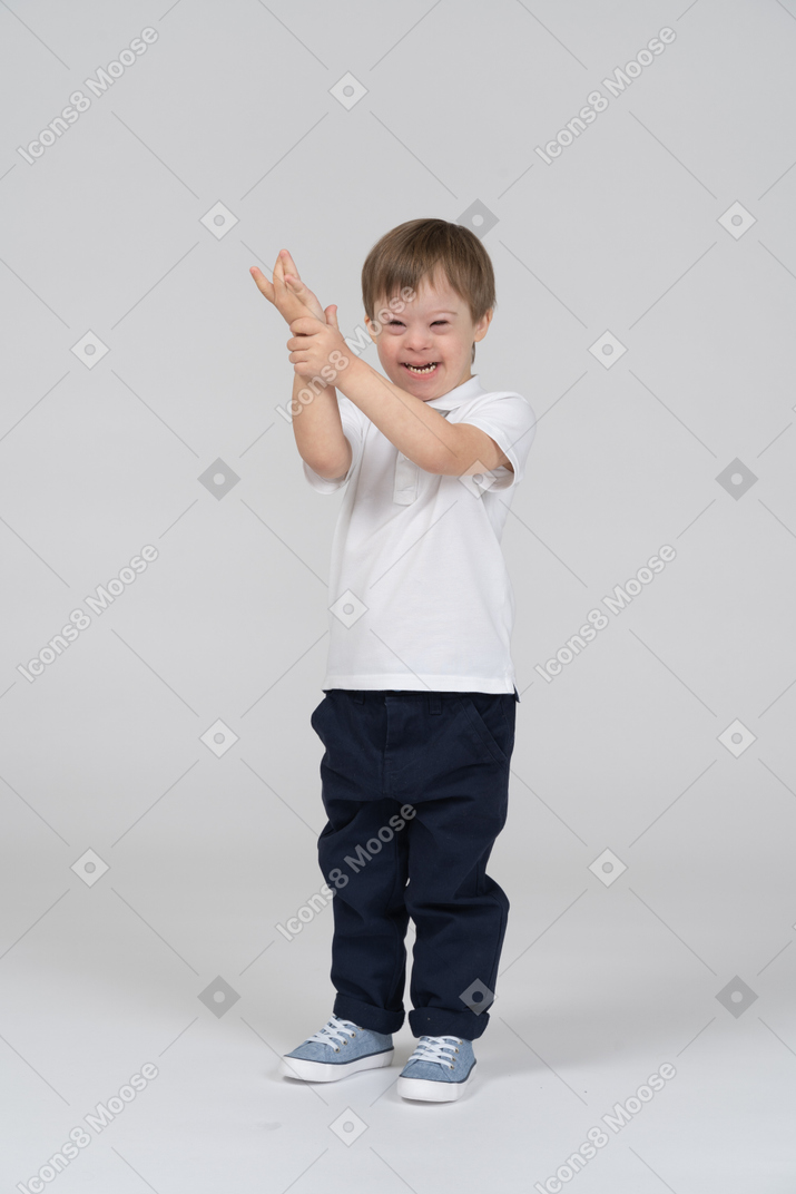 Laughing little boy raising his hand