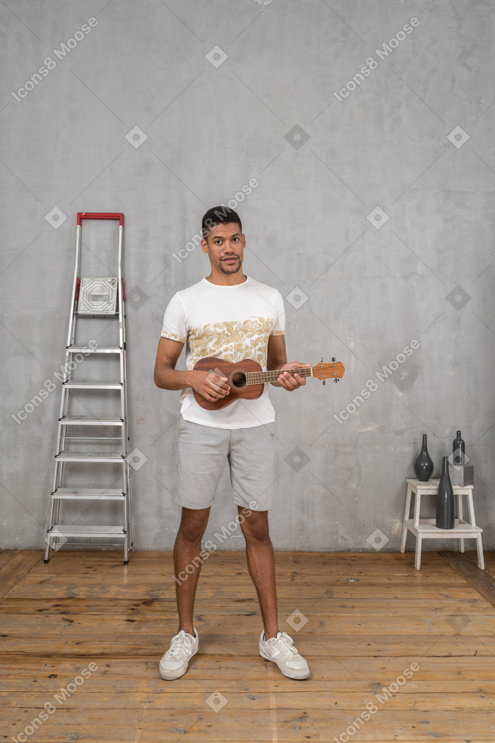 Vista frontale di un uomo che suona l'ukulele