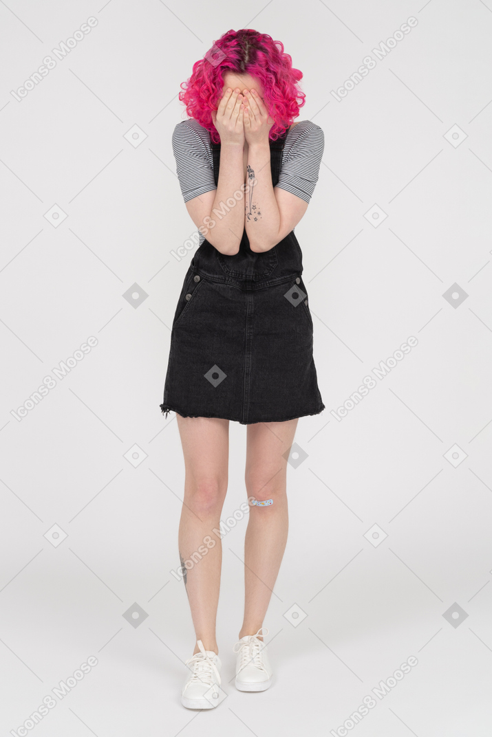 Teenage caucasian girl covering face with both palms