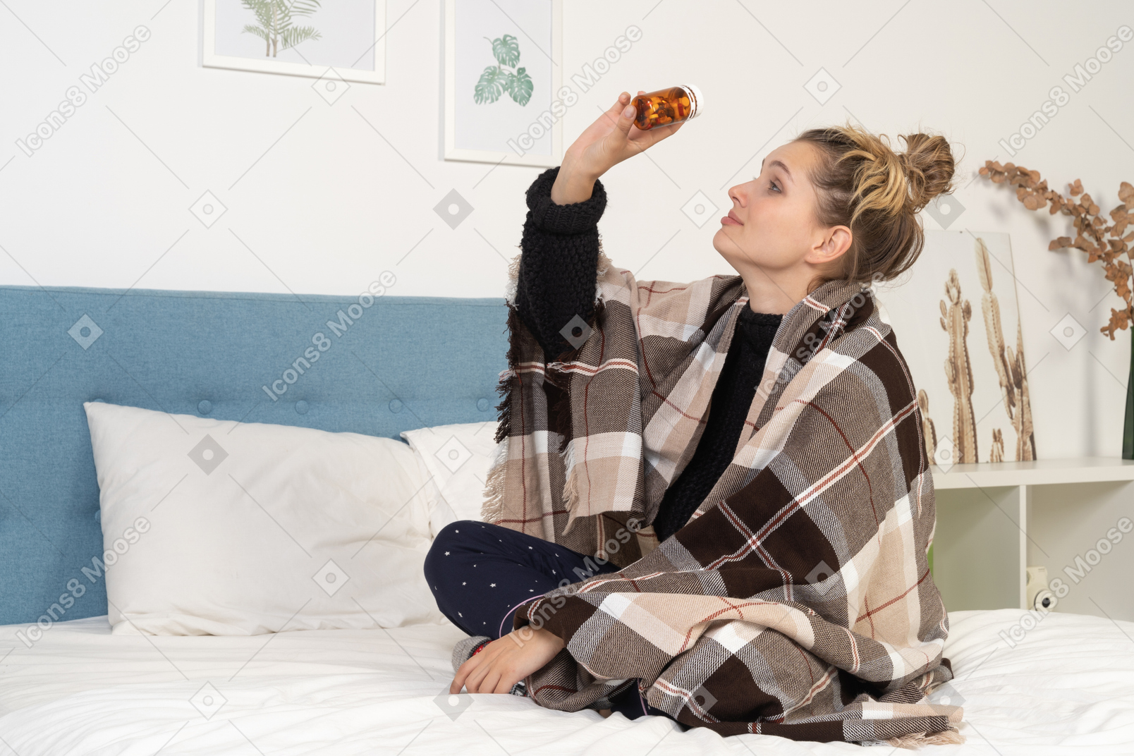 Side view of an ill young lady in pajamas with pills wrapped in checked blanket in bed