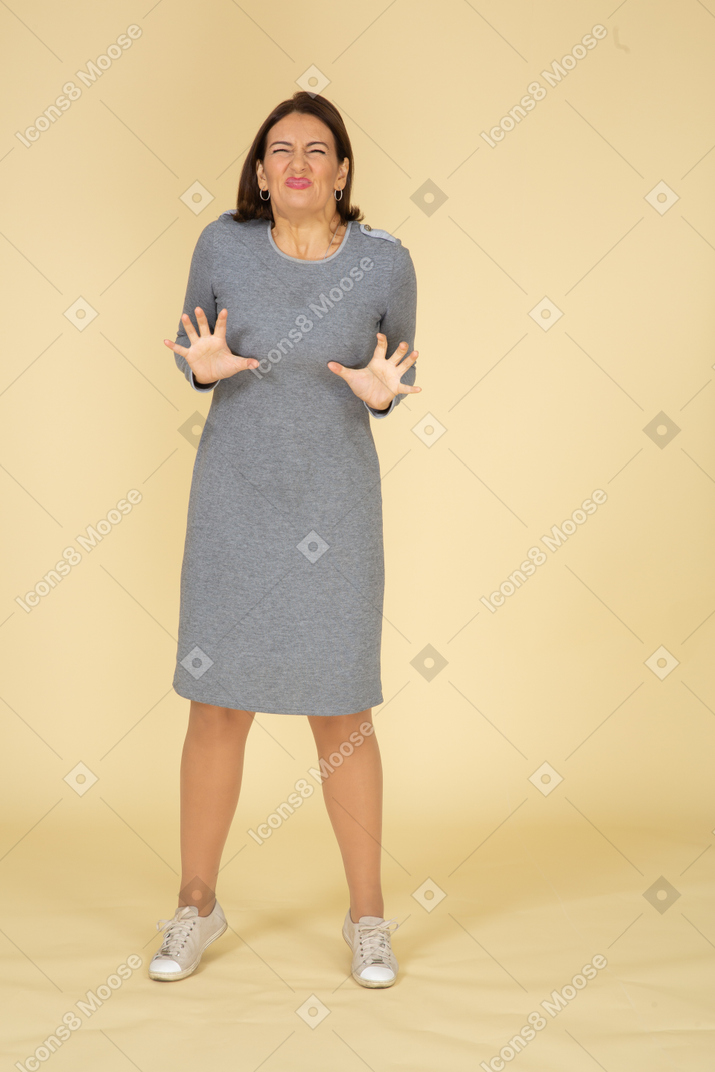 Front view of a woman in grey dress gesturing