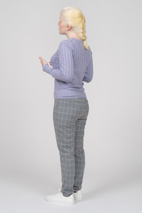 Three-quarter back view of a young woman speaking and gesturing