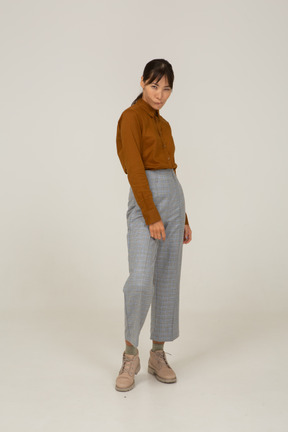Vista frontal de una mujer asiática joven sospechosa en calzones y blusa