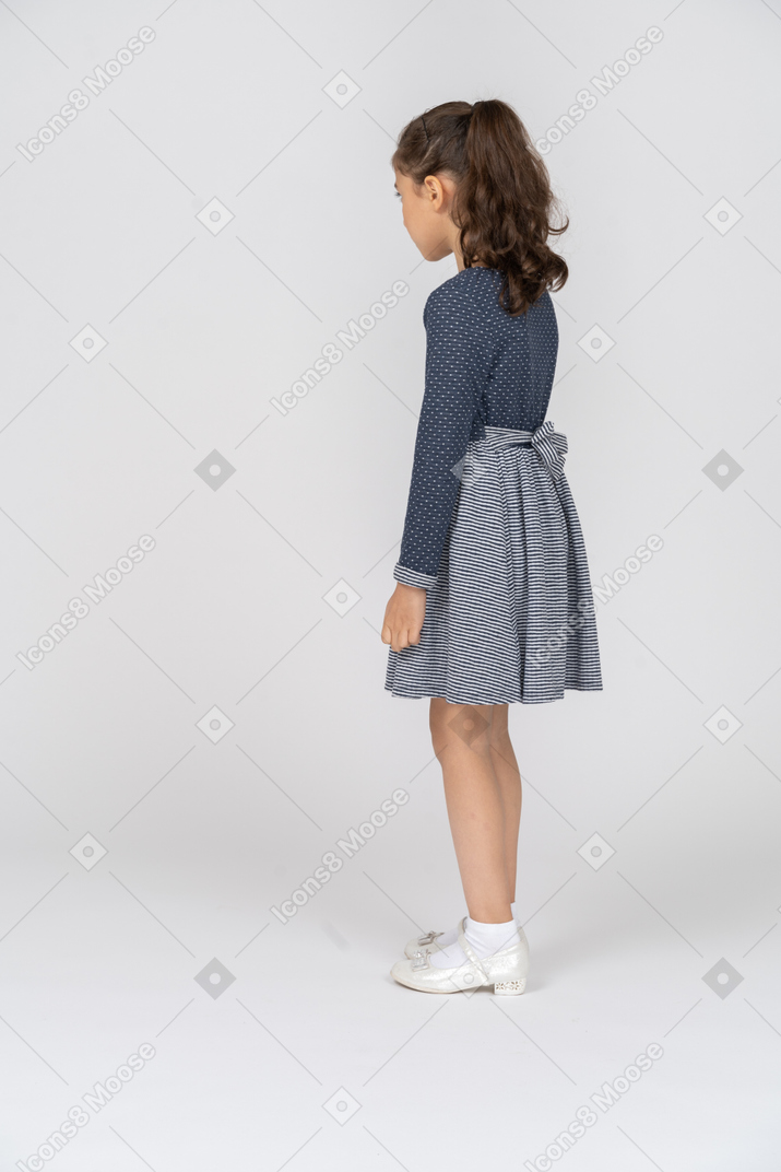 Vista posteriore di tre quarti di una ragazza in piedi