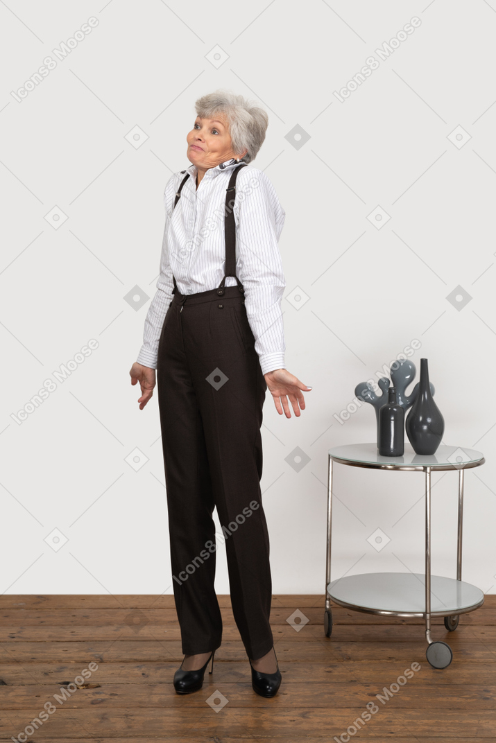 Three-quarter view of a perplexed old lady outspreading her hands