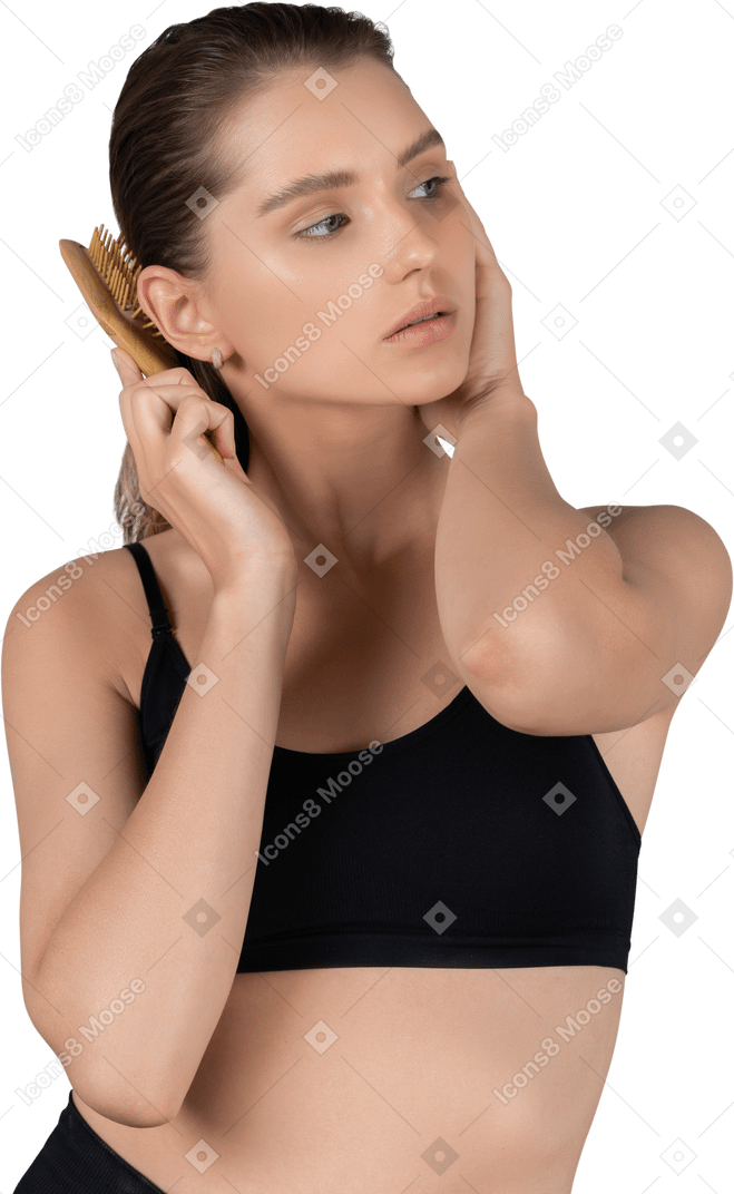 Front view of a young woman brushing her hair