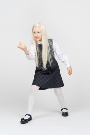 Schoolgirl with long hair beckoning with finger