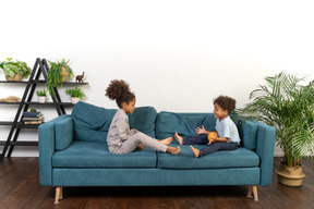 Good looking boy and girl play on the sofa