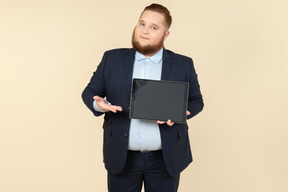 Joven oficinista con sobrepeso mostrando tableta digital