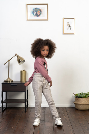 Cute girl kid posing on the apartments background