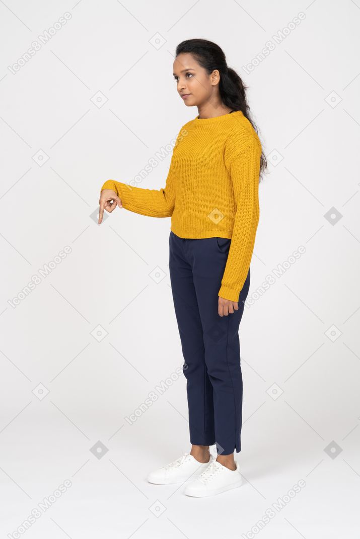 Side view of a girl in casual clothes pointing down with a finger