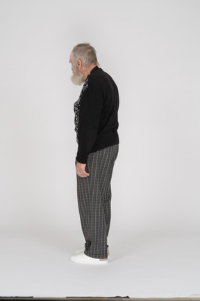 Вид сзади на пожилого мужчину в клетчатых брюках, стоящего