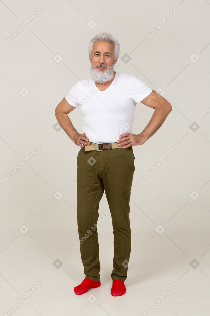 Mann in freizeitkleidung posiert mit den händen auf der taille