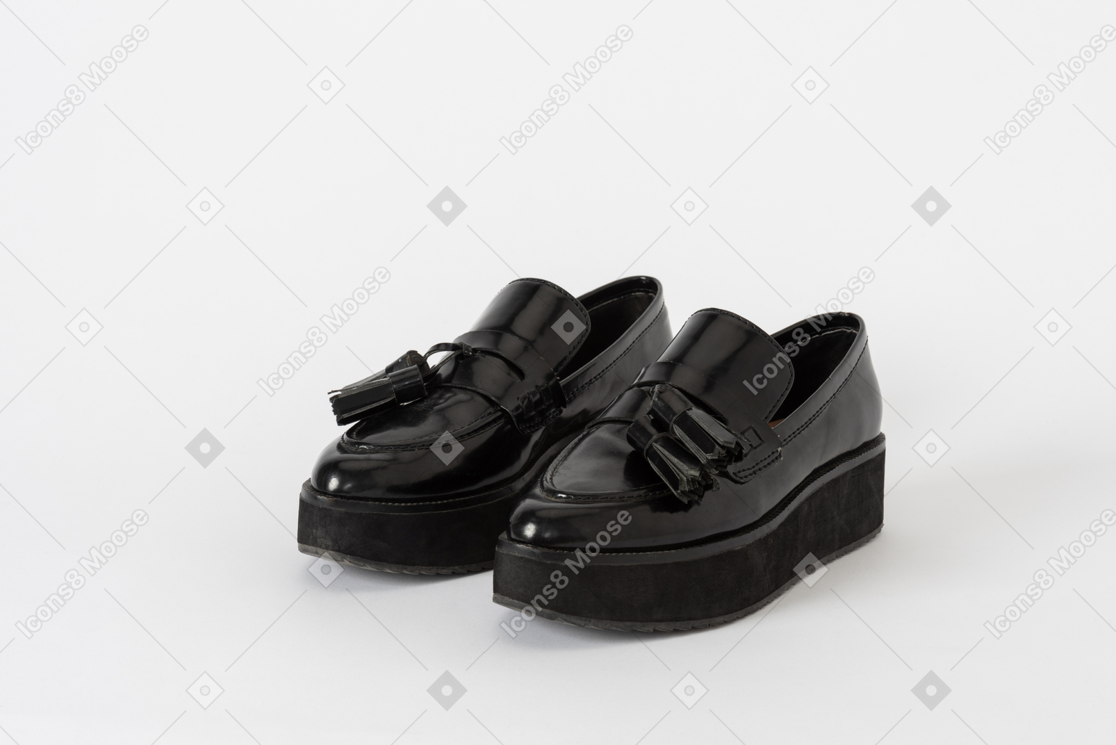 A three-quarter front shot of a pair of black lacquer platform loafer shoes