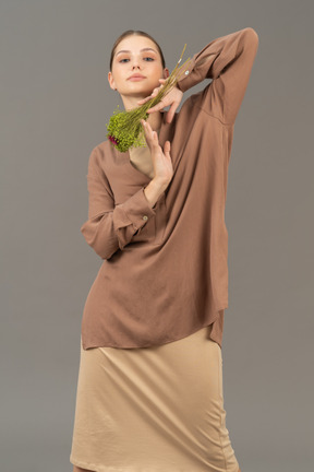 Jeune femme posant avec bouquet