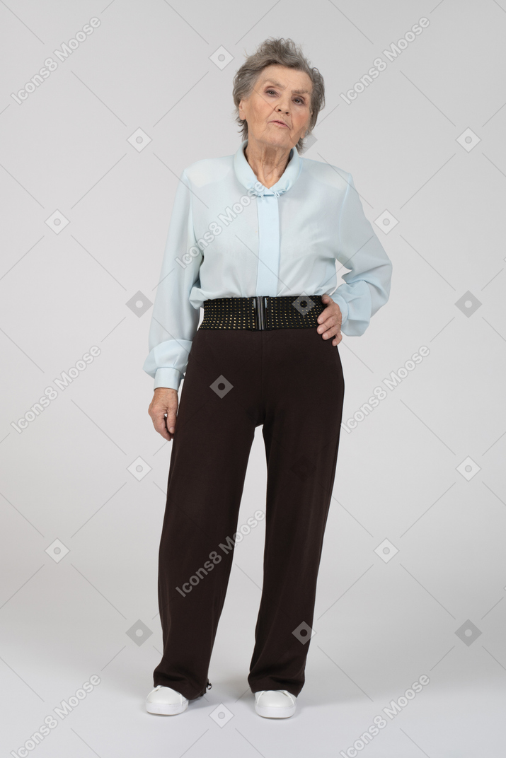 Vue de face d'une vieille femme avec une main sur sa hanche