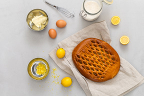 Zitronen, zitronenschale, glas mit zucker, butter, eiern und zitronenkuchen