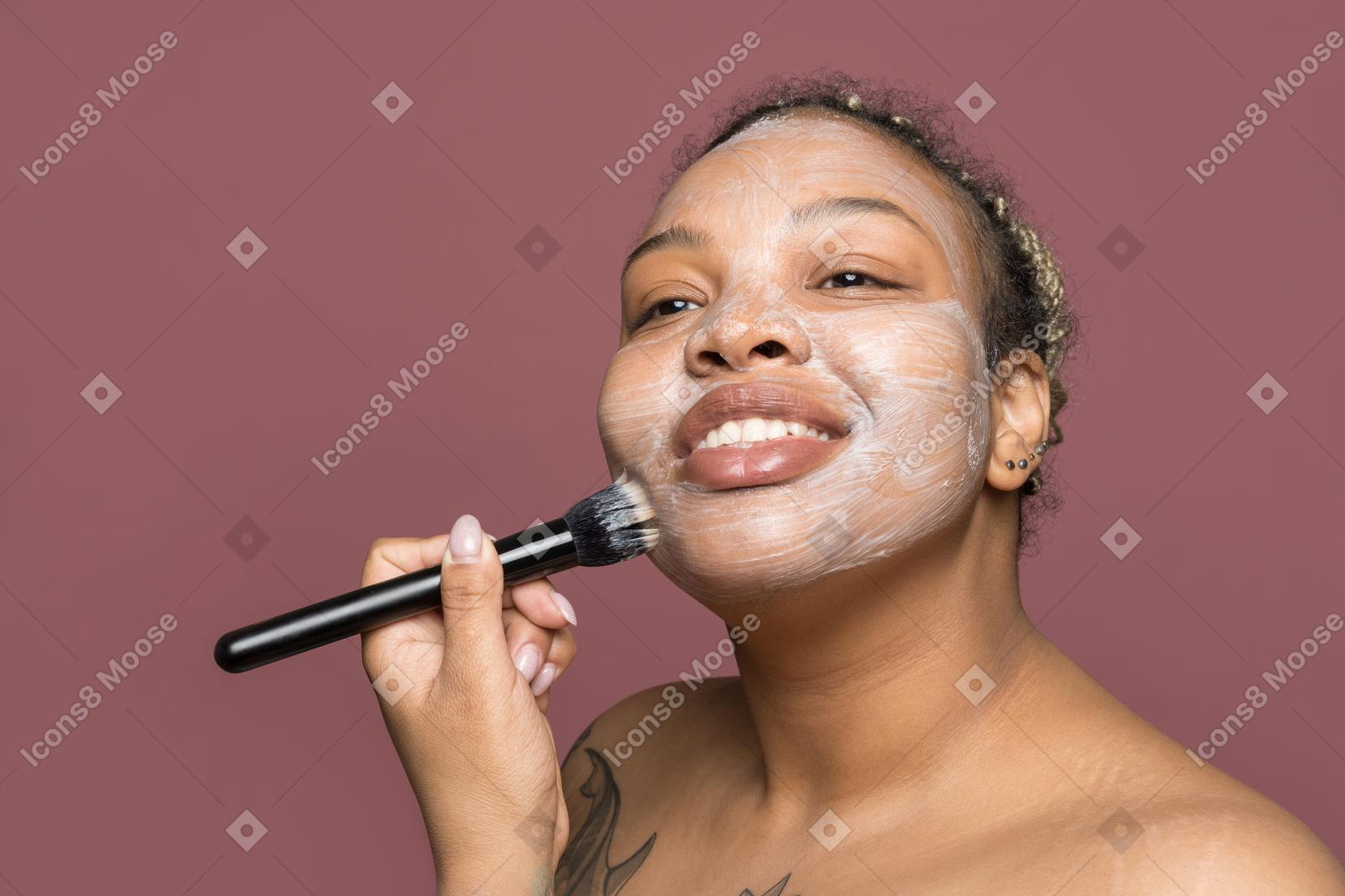 Smiling african-american woman applying a face cream