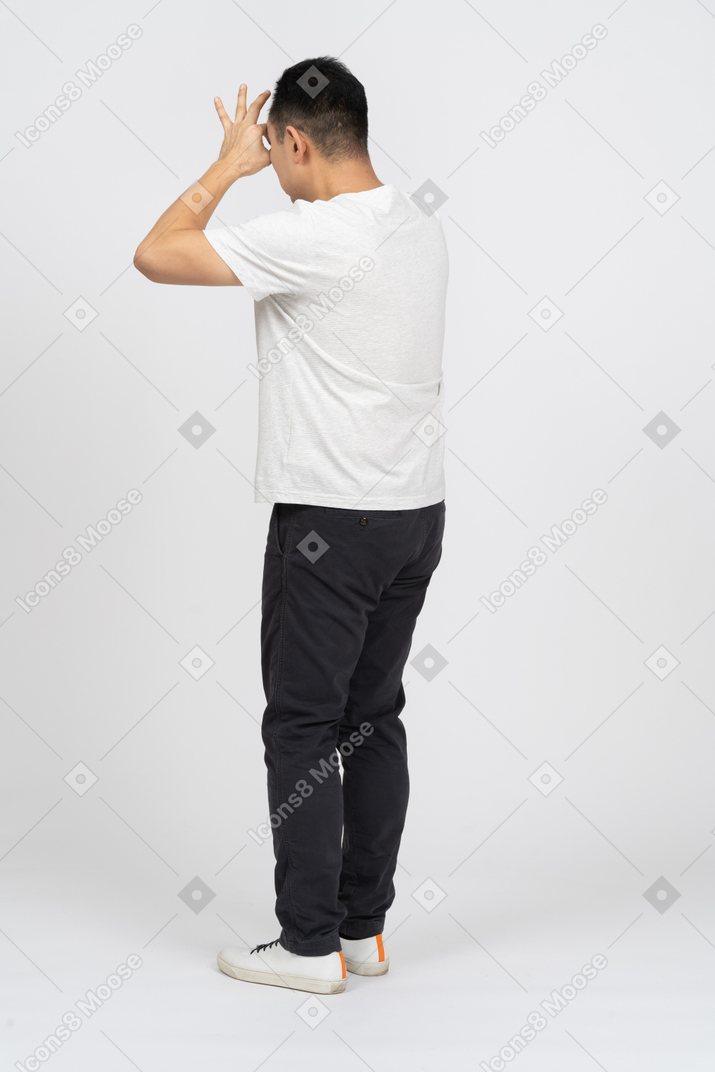 Side view of a man in casual clothes looking through fingers
