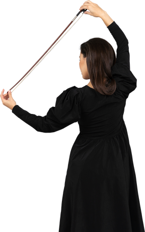 一位身穿黑色连衣裙、手持蝴蝶结的年轻女士的背影