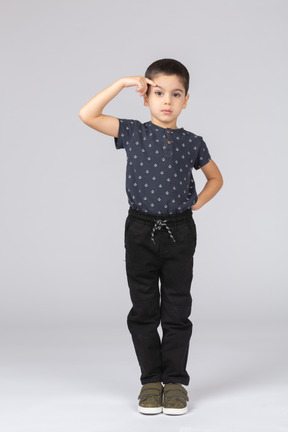 Вид спереди симпатичного мальчика в повседневной одежде, указывающего на лоб