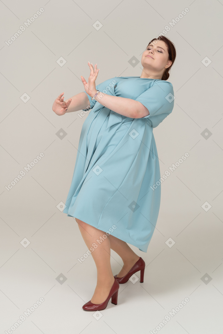 一个穿着蓝色连衣裙跳舞的女人的侧视图