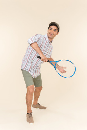 Giovane uomo caucasico che tiene la racchetta da tennis