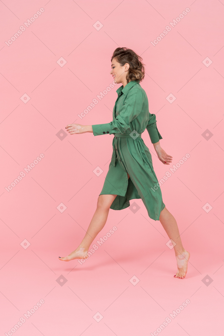 Woman in green dress walking sideways