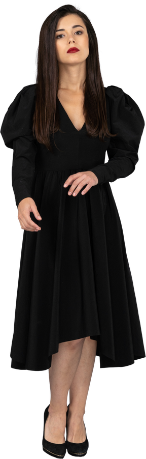 Vista frontale di una giovane donna in un abito nero