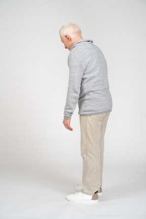 Side view of a man standing and looking down