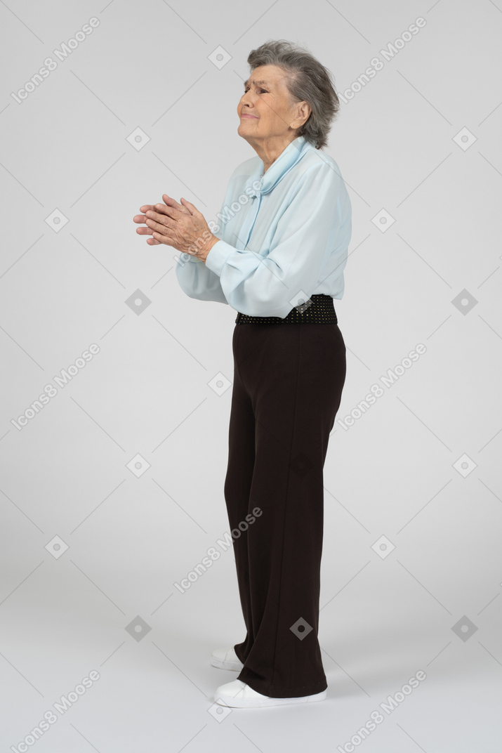 Old woman pleading with hands clasped