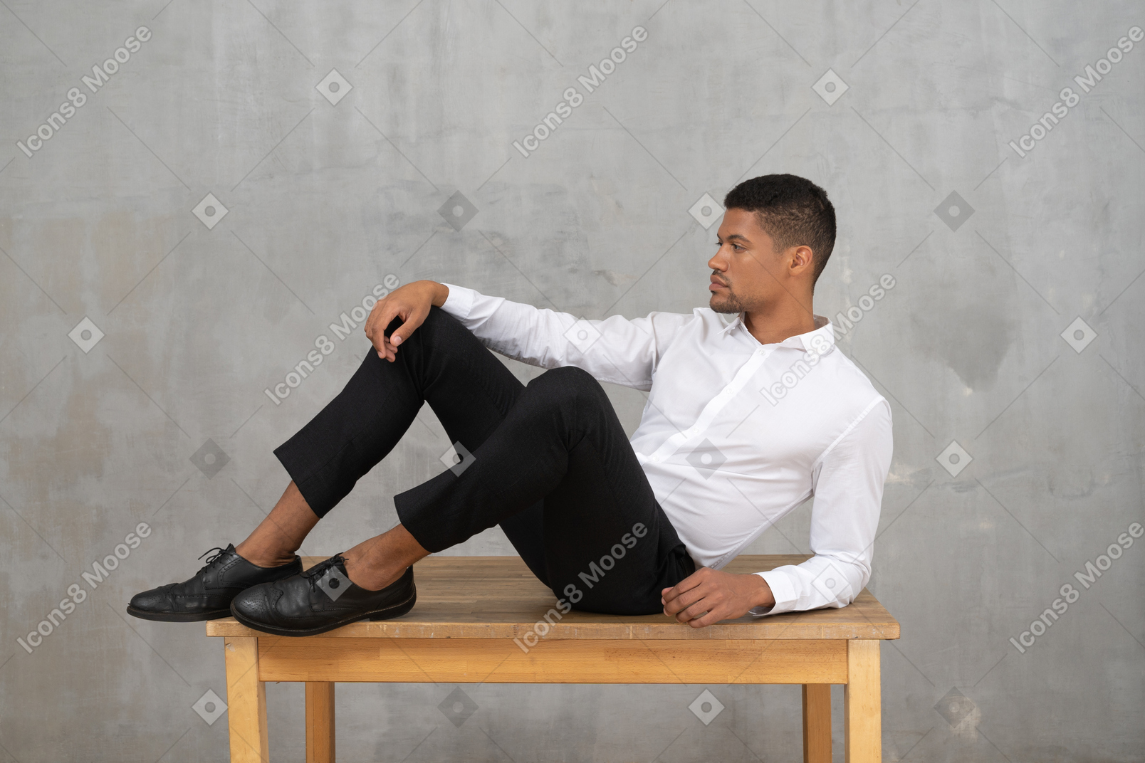 Uomo in abiti formali sdraiato su un tavolo