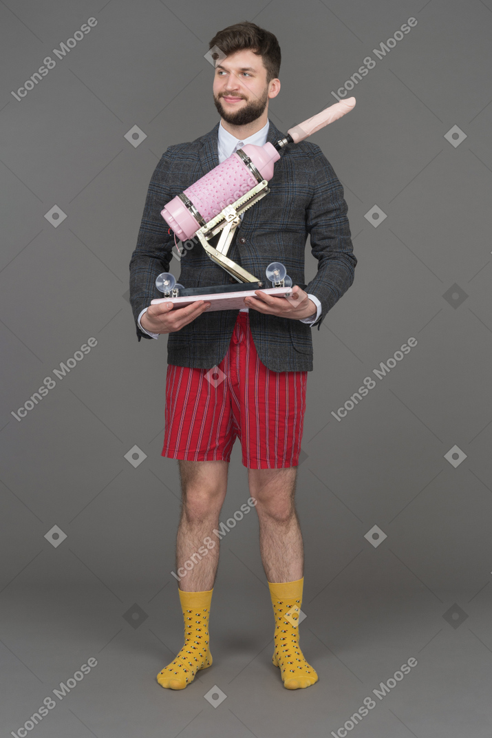 Man holding sex machine and looking aside