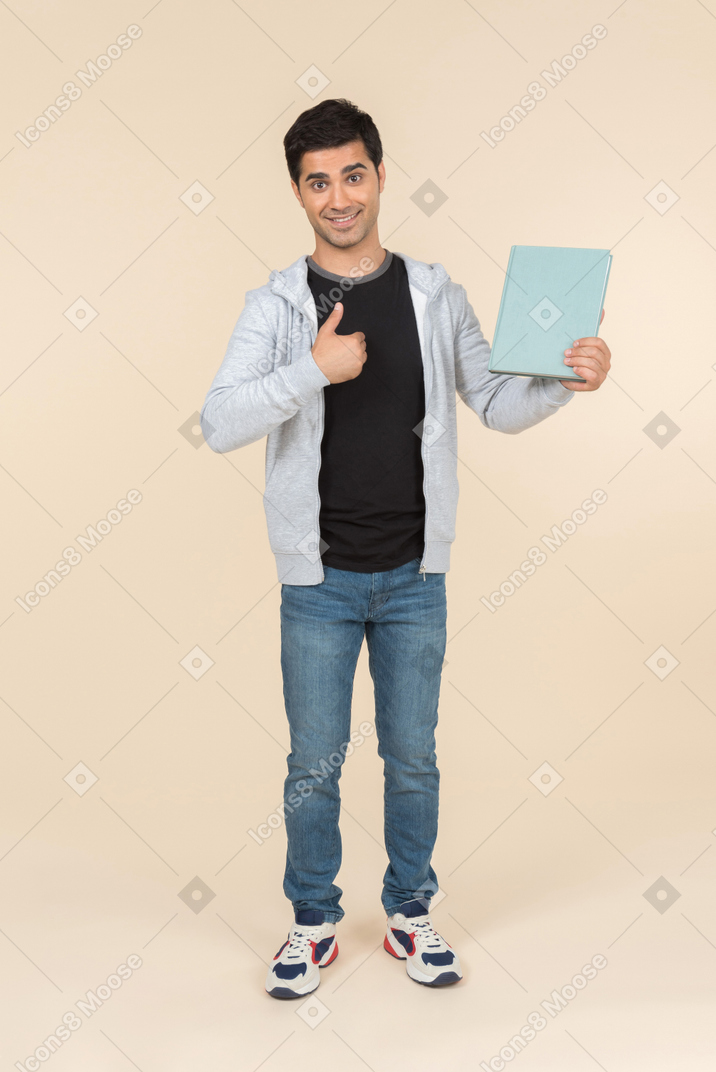 Jeune homme de race blanche pointant au livre qu'il tient