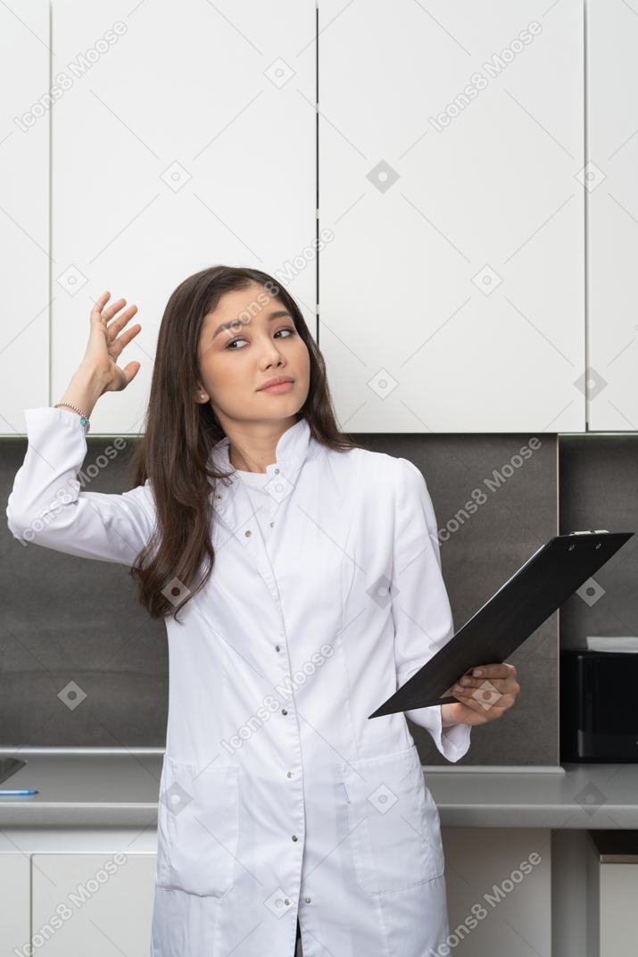 困惑的护士举起她的手，拿着一台平板电脑的前视图