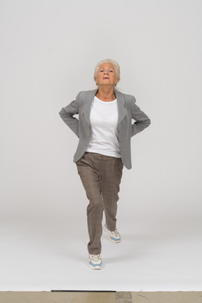 Front view of an old lady in suit doing yoga