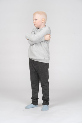 Three quarter view of a little boy with crossed hands