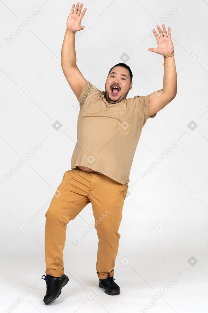 Asian man surrendering with his hands up in the air