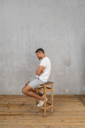 Side view of young man sitting and laughing