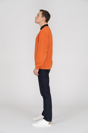 Young man in orange sweatshirt standing