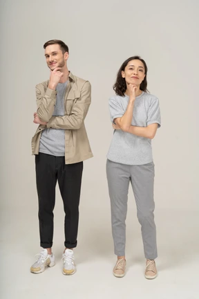 Pareja joven sonriendo con la mano en la barbilla