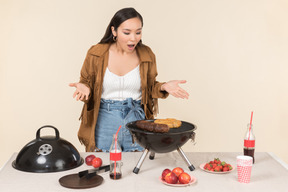 Joven asiática que tiene problemas con la barbacoa